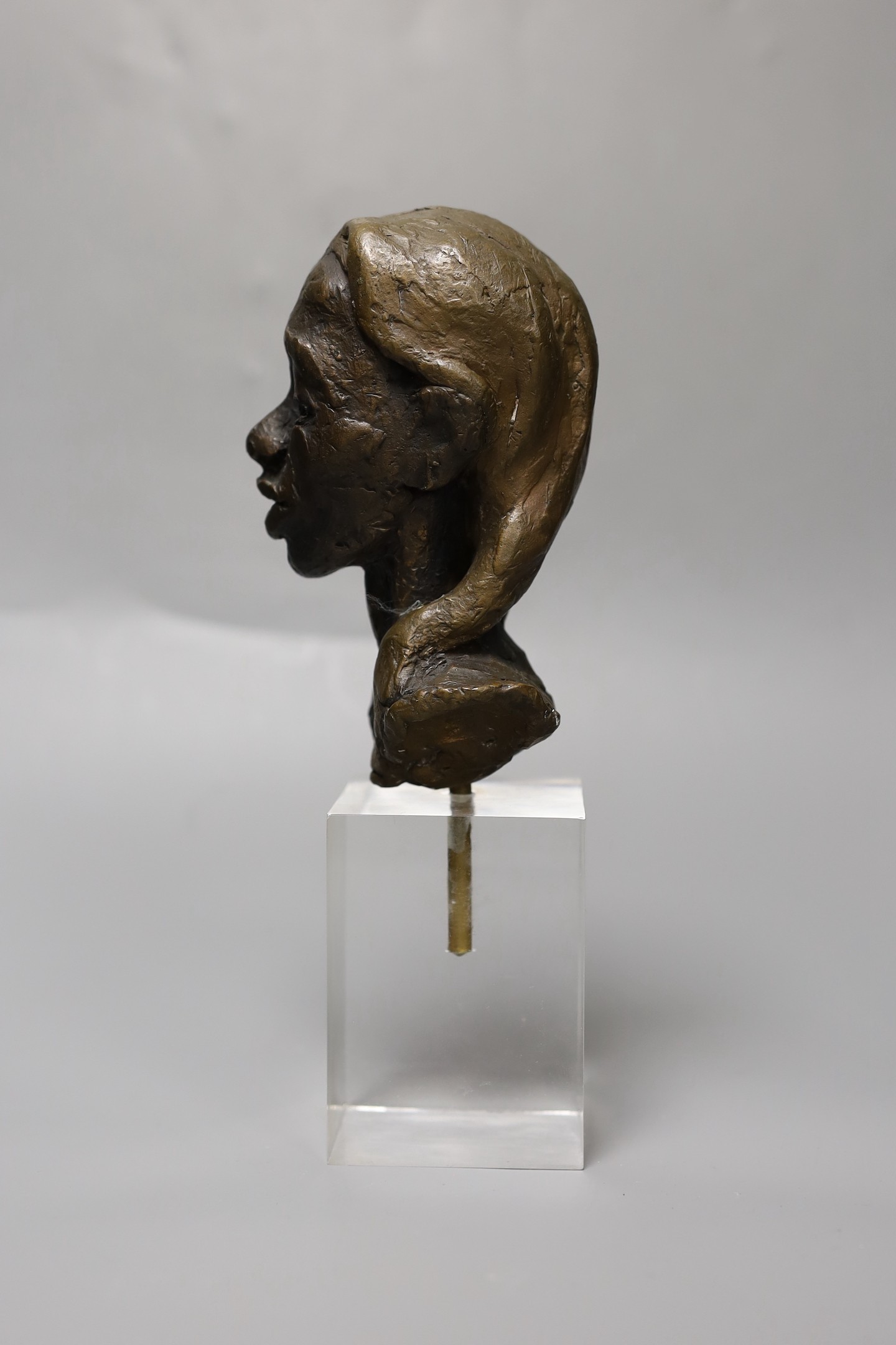 An abstract bronze bust of a girl, on perspex plinth, 24cm